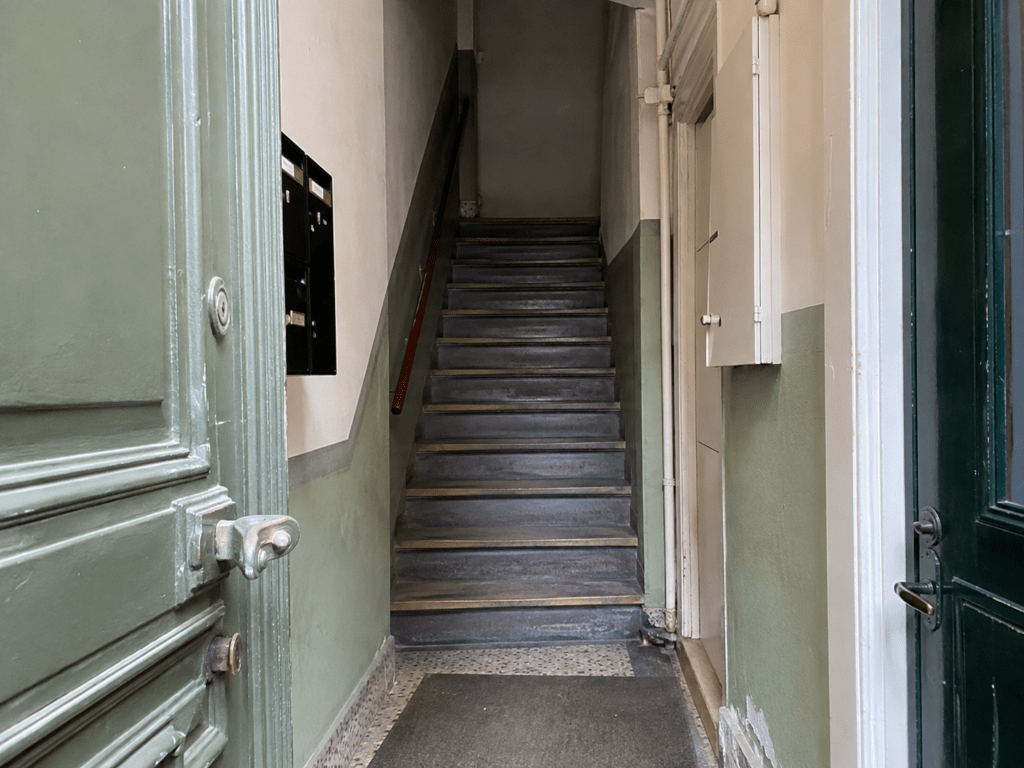 Klassisk opgang i ældre etageejendom i København SV med trapper og hoveddør