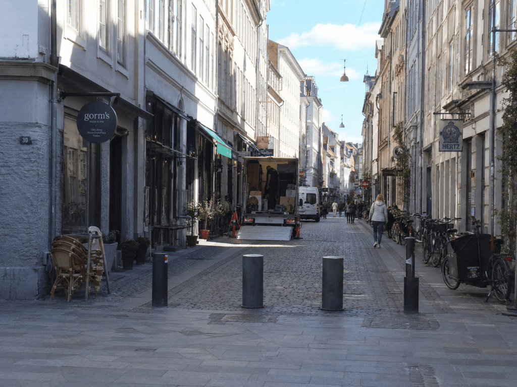 Smal sidegade i København K med parkerede biler og klassiske etageejendomme