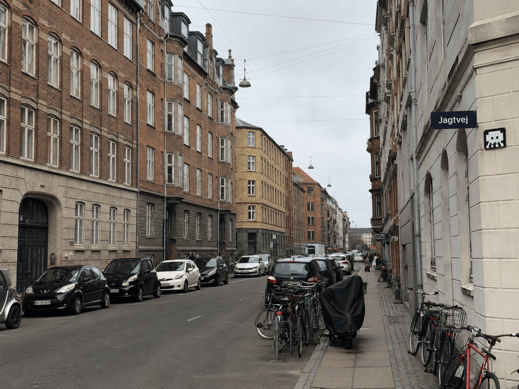 Jagtvej på Nørrebro med trafik, etageejendomme, butikker og parkerede biler