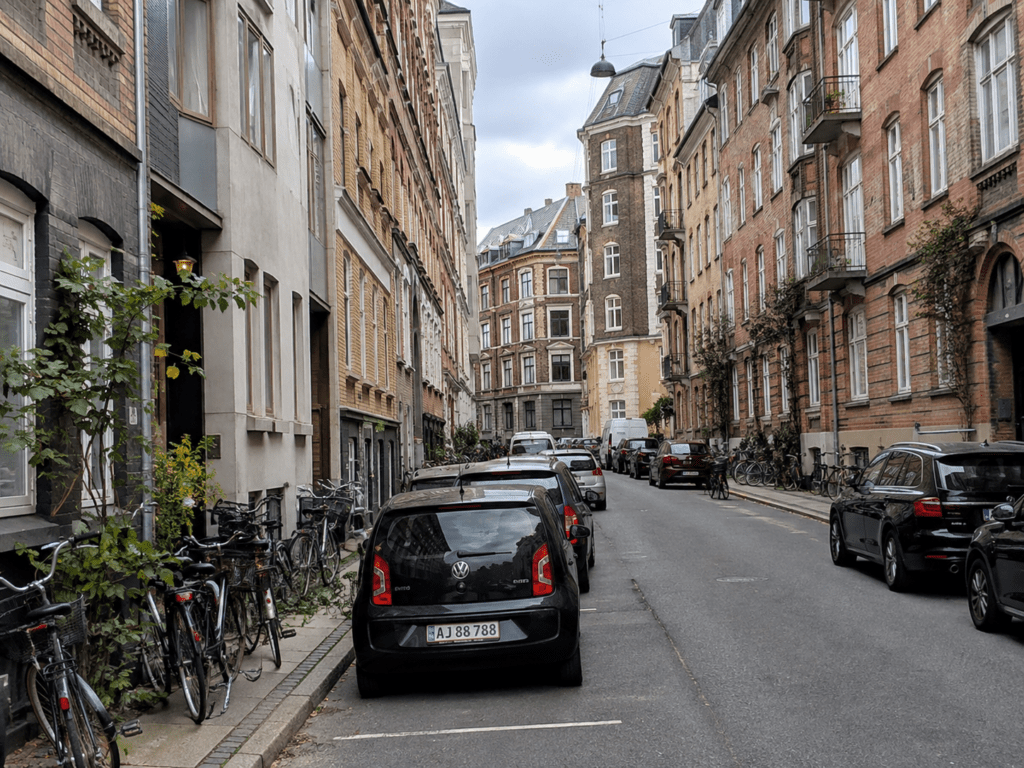 Smal sidegade på Frederiksberg med parkerede biler og klassiske etageejendomme