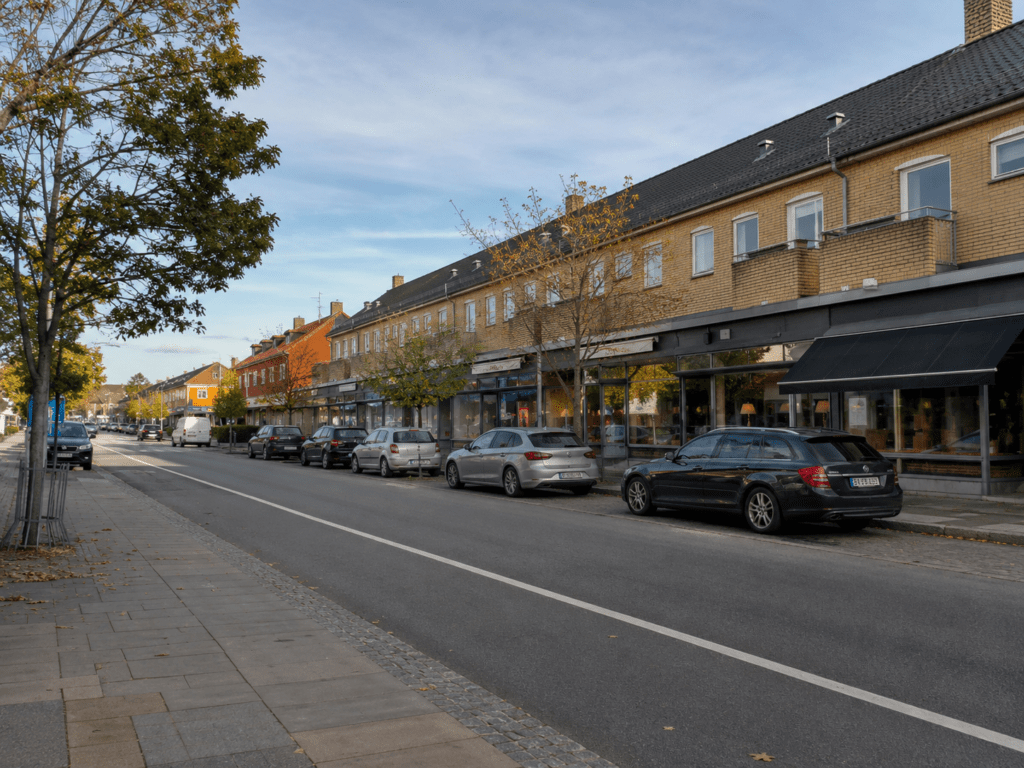 Lokalt butiksområde i Hvidovre med butikker, parkerede biler og mindre erhverv