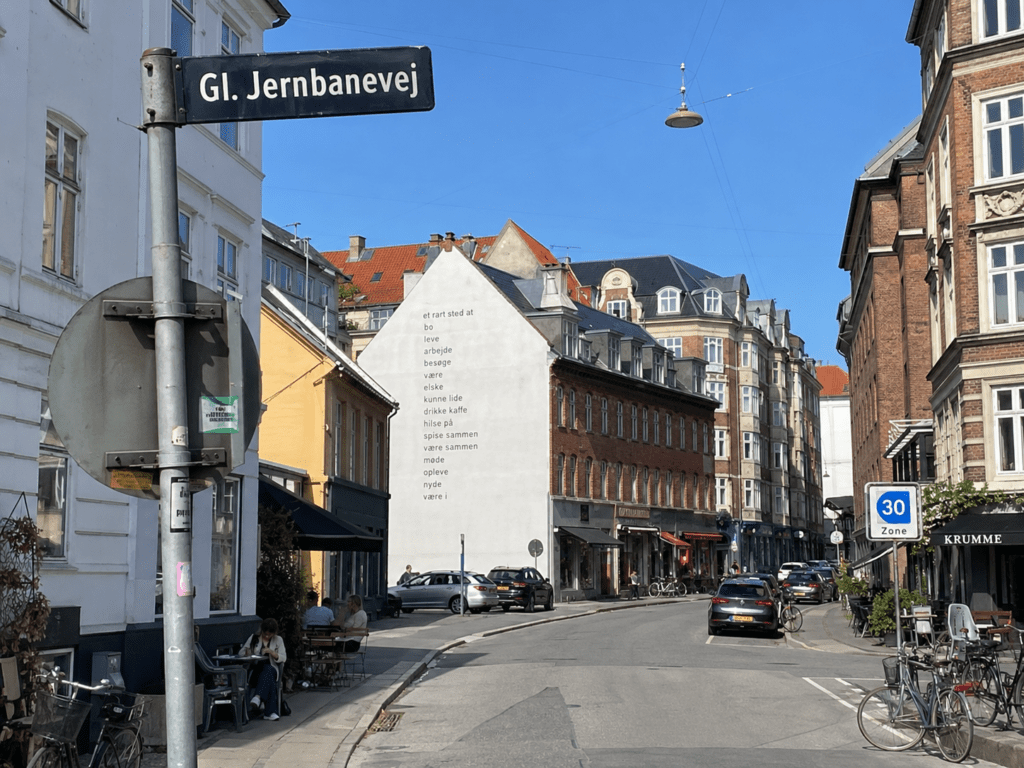 Gl. Jernbanevej i Valby med klassiske bygninger, butikker, caféer og lokalt bymiljø