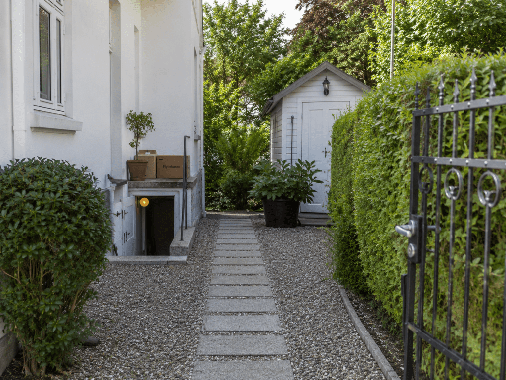 Havegang ved villa i Klampenborg med kælderadgang, skur og flyttekasser