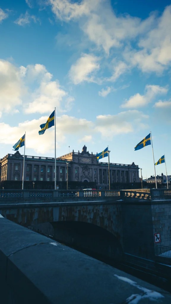 Riksdagen i Stockholm med svenske flag – flyt til Sverige